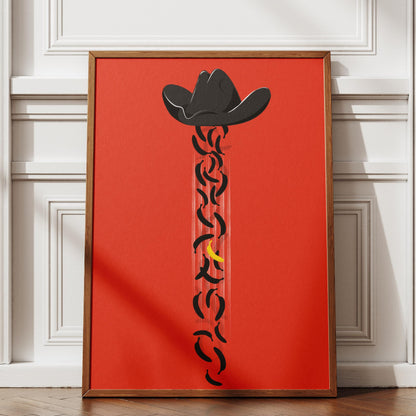 Framed artwork with a cowboy hat design on a red background, displayed in a room with white walls and wooden floor.